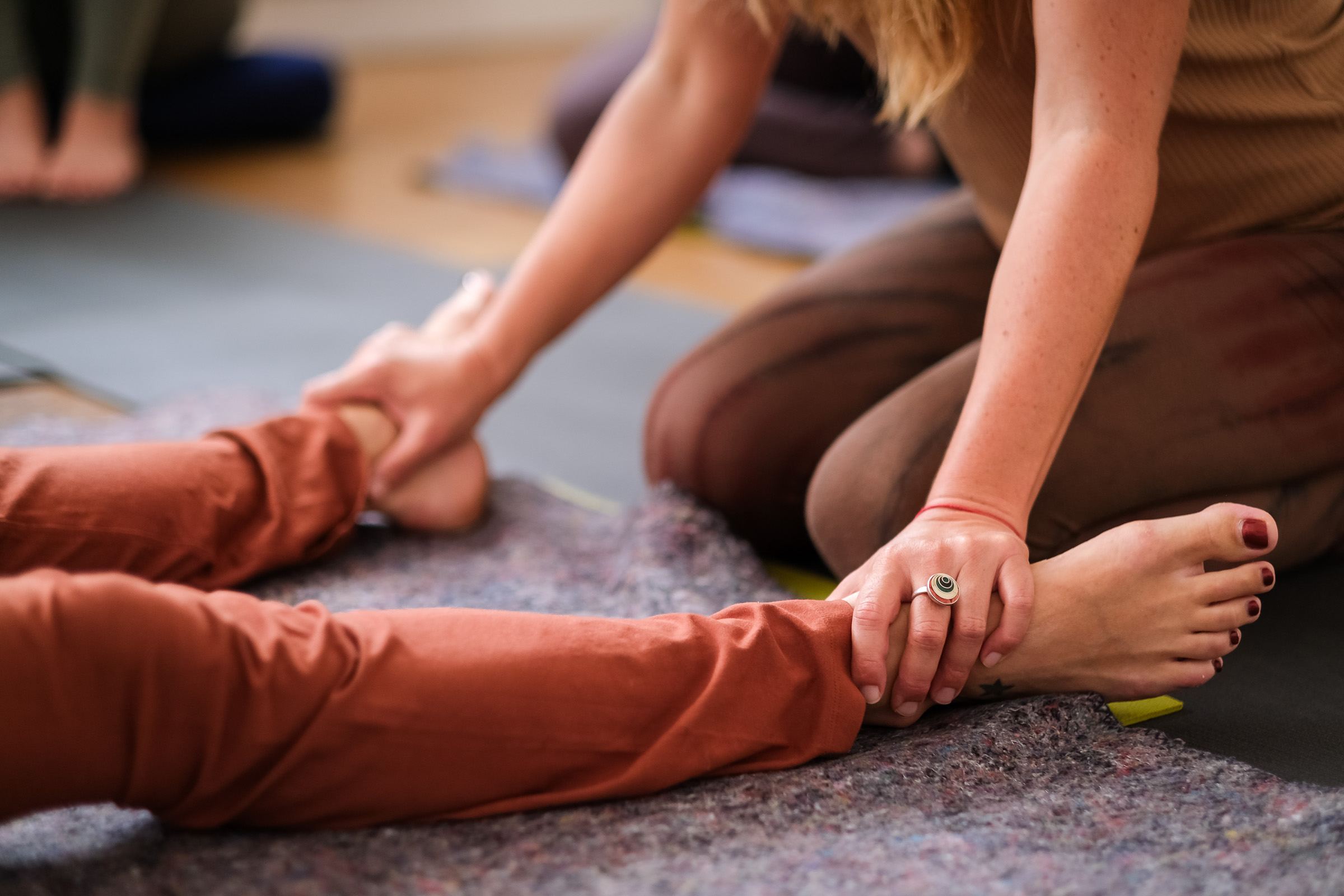 Hands holding a participant’s feet during a bodywork session